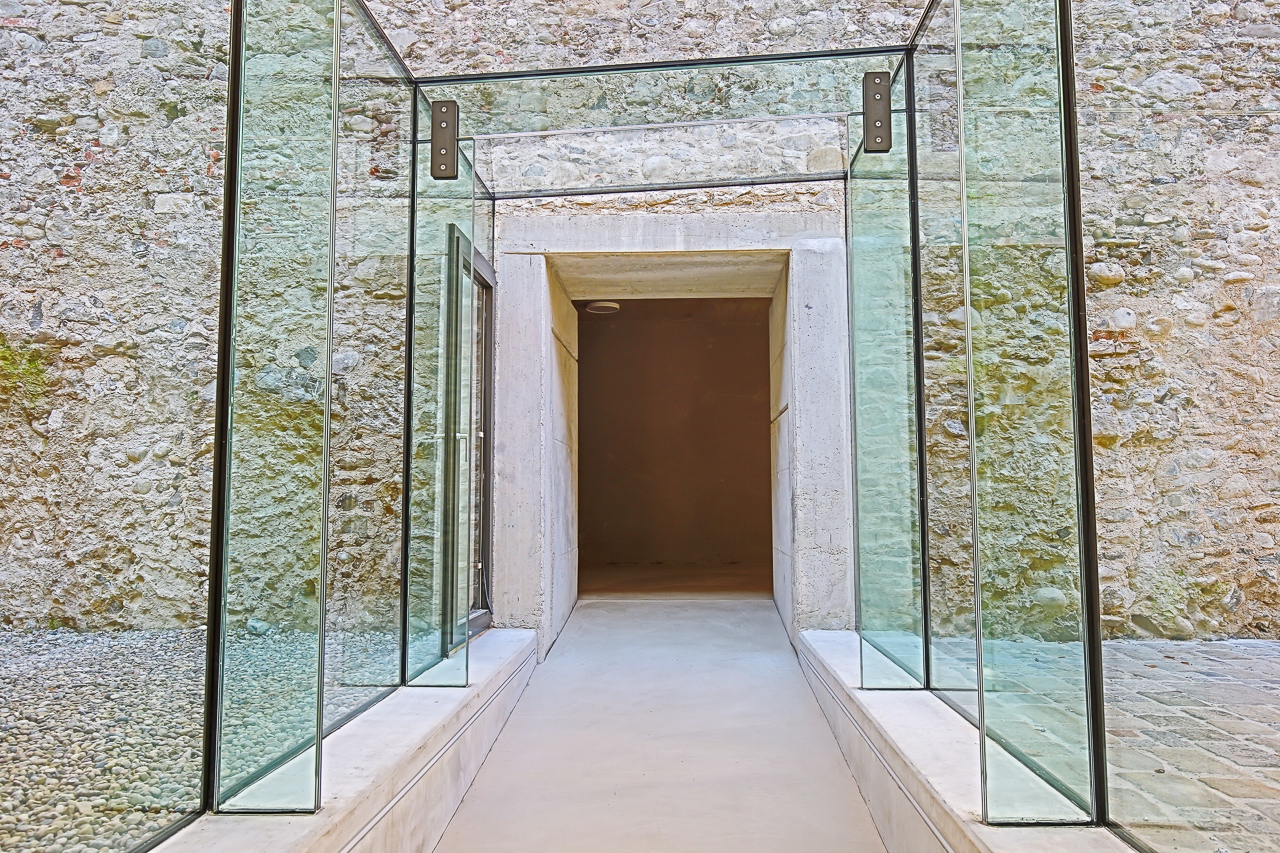 Transparente Glasstruktur mit einem Eingang zu einem Raum in einem modernen Gebäude.
